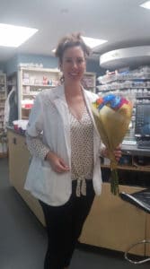 Carolyn Cox standing while she holds flowers