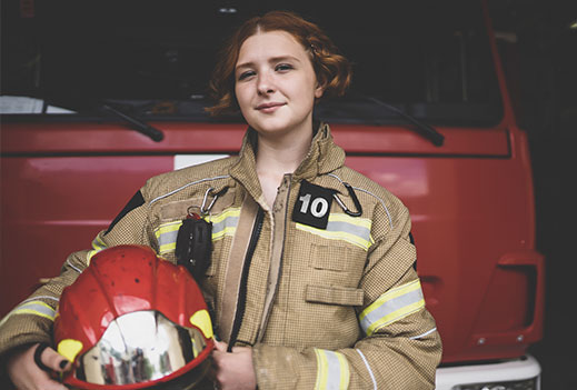 female firefighter in front of firetruck