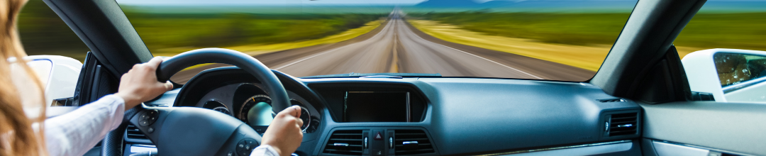 Female driving on a highway looking out the front windshield