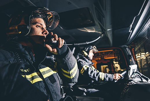 Two volunteer figherfighters in firetruck.