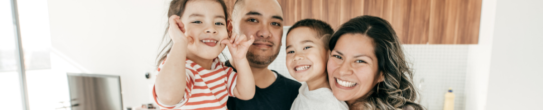 Mother, father, and 2 daughters smiling